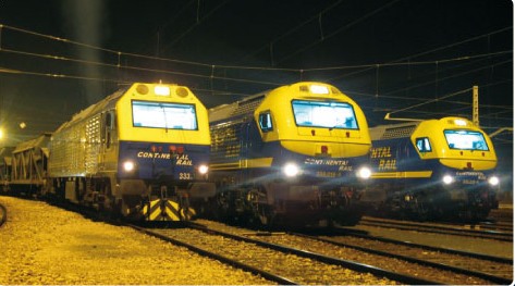 Tres locomotoras 333 de Continental Rail estacionadas de noche en una playa de vías.
