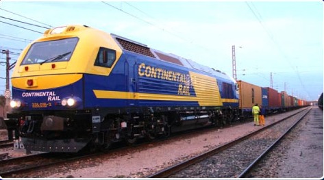 Locomotora 333 de Continental Rail con tren de contenedores al atardecer, con operario en vía.
