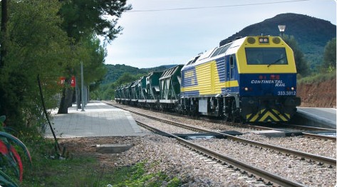 Locomotora 333 de Continental Rail con tren de tolvas en un tramo de montaña.